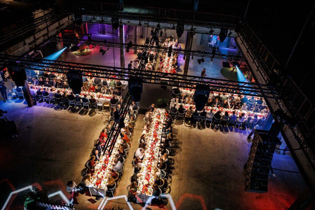 Een bovenaanzicht van de Middenfabriek waar mensen aan tafels zitten te eten.
